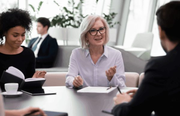 A diverse group of people engaged in conversation around a table, sharing ideas and discussing various topics