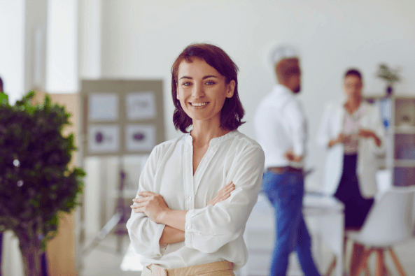 A woman stands confidently in front of a diverse group of people, engaging them with her presence