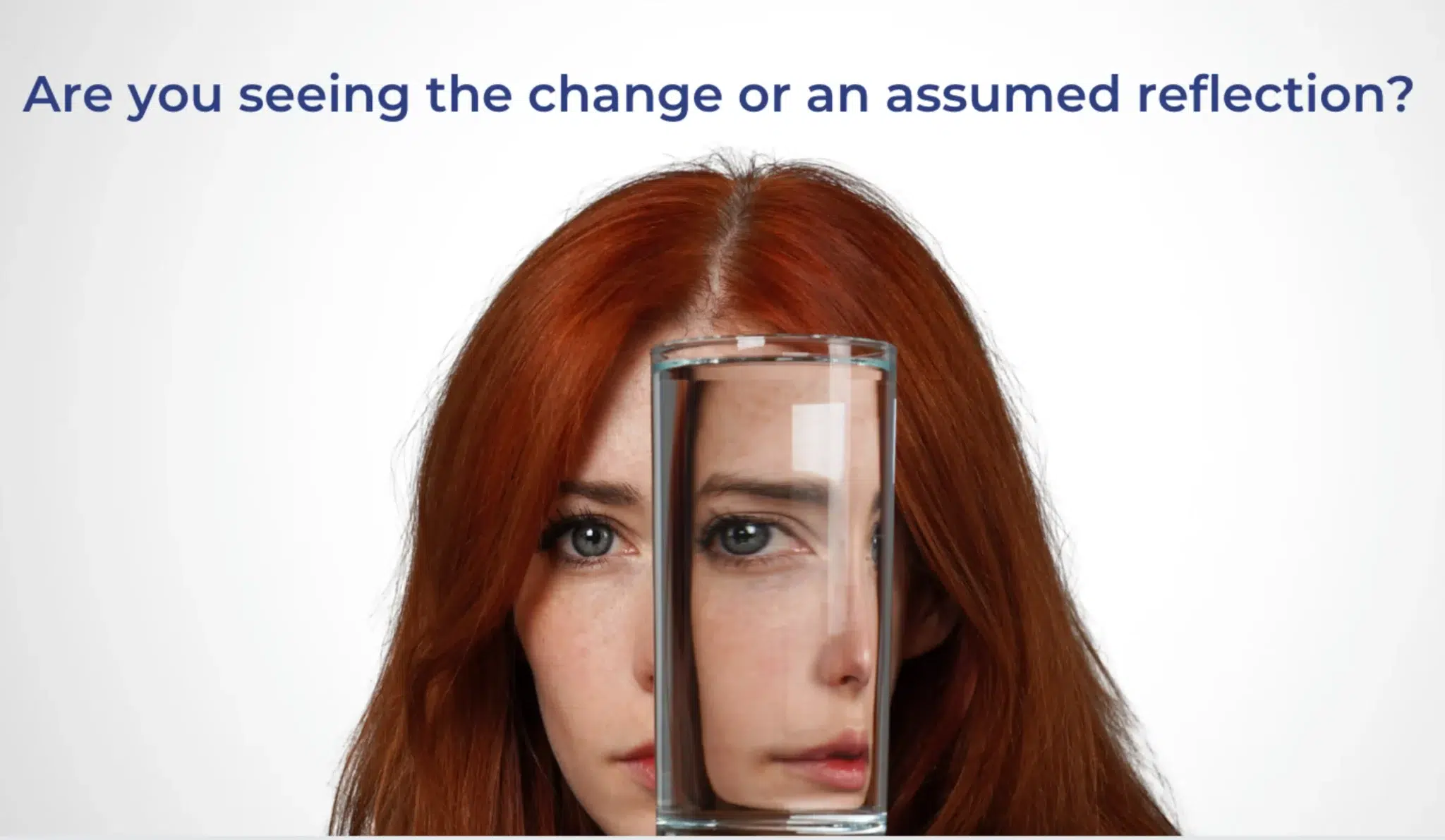 A woman with red hair, her face partially obscured and distorted by a clear glass of water held directly in front of her.