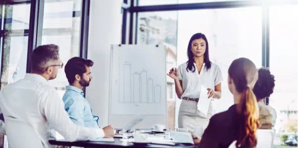 Businesswoman confidently presenting a chart despite hidden struggles.