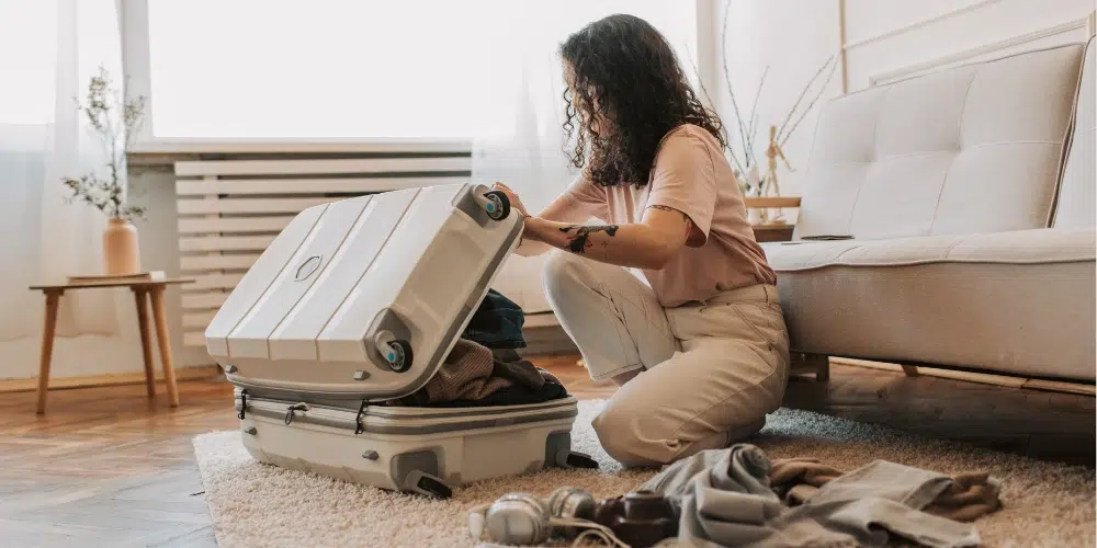 A hand reaching out and pulling open an empty wooden desk drawer.
